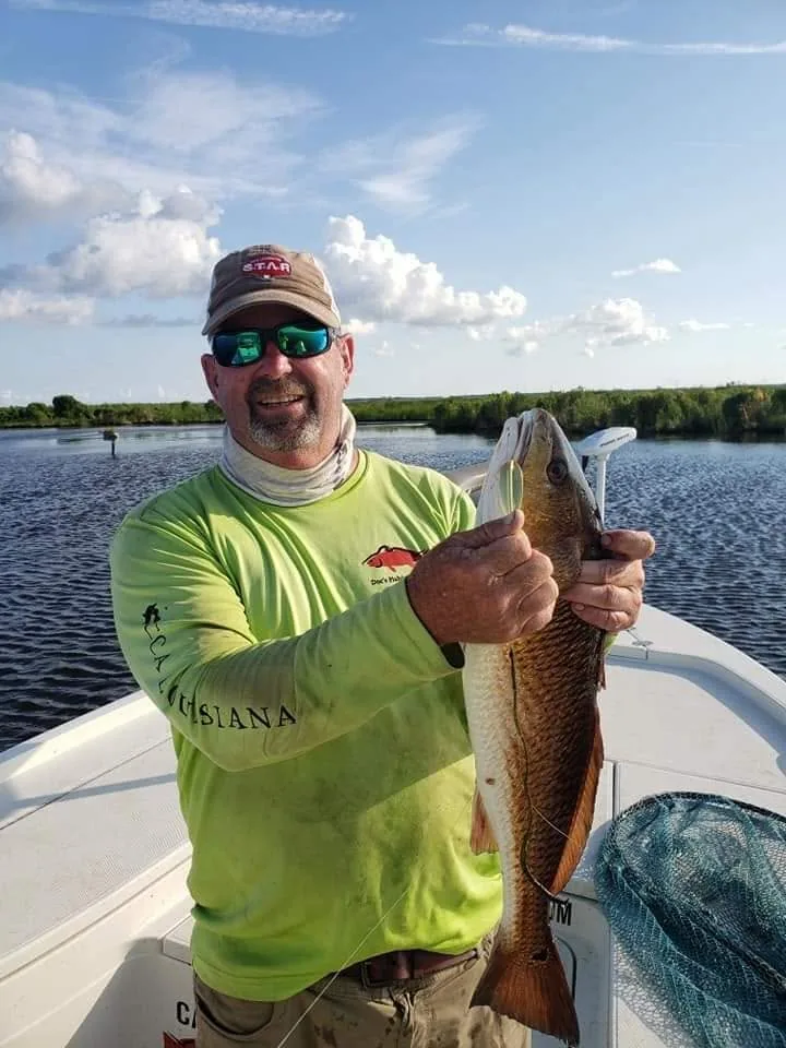 Captain Maurice Doc d’Aquin holding a redfish
