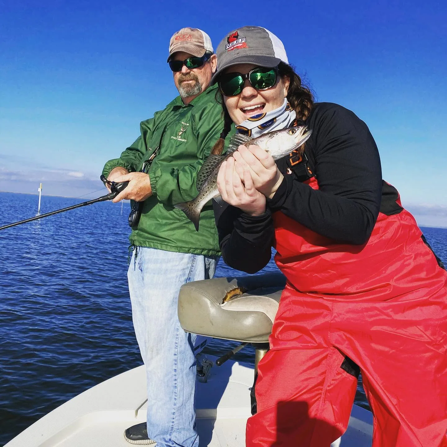 Guest displaying a catch with Captain Doc nearby